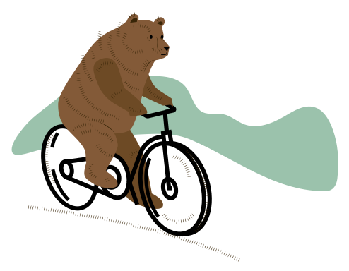 A brown bear riding a bicycle on a hill.