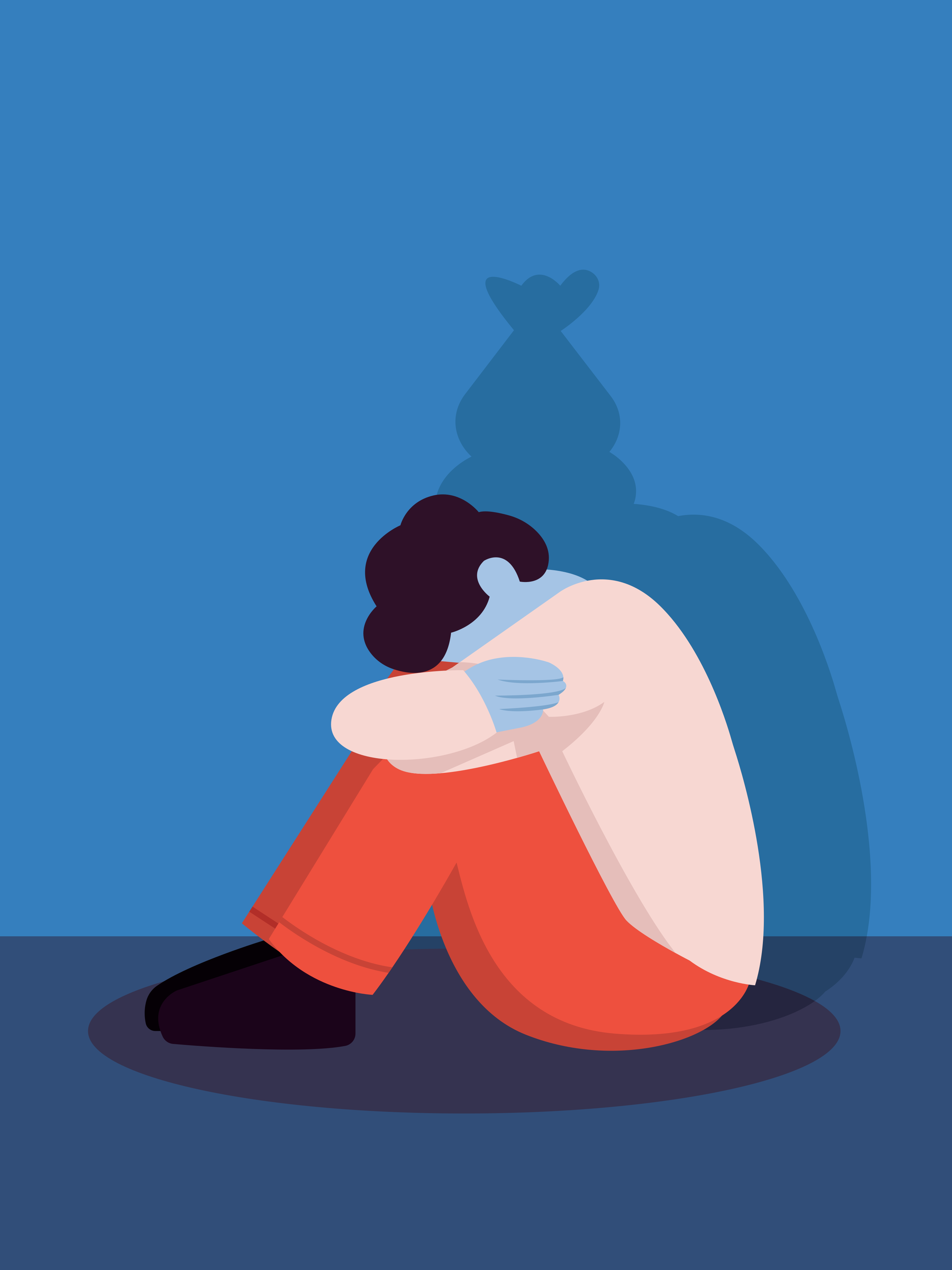 A person sits hunched over with their shadow looming large