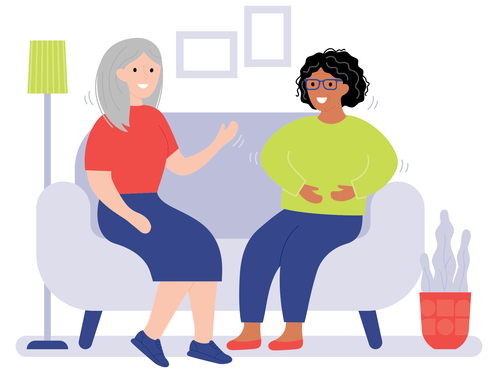 Two women talking while sitting on a couch.