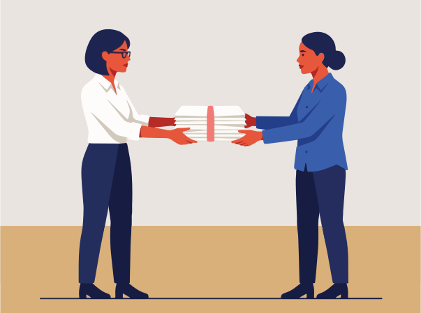 Two women exchange a stack of papers.