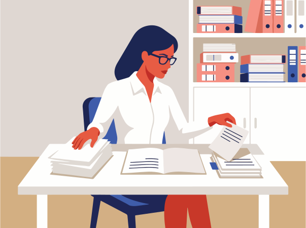 Woman in glasses sorts papers at a desk