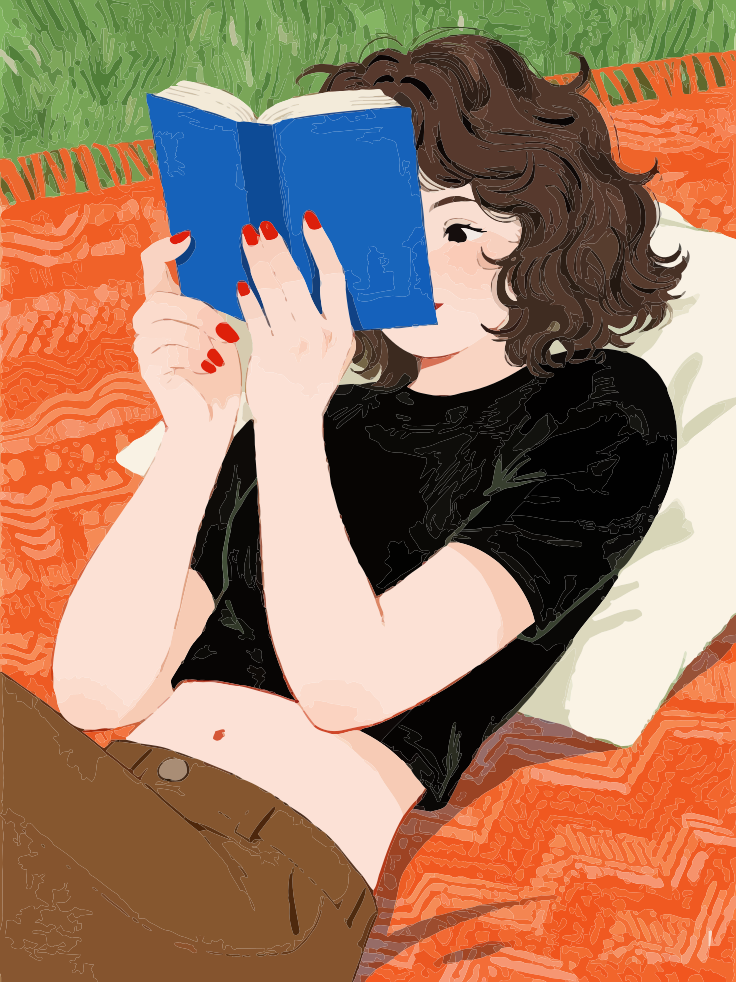 Young woman reading a blue book on a blanket outdoors