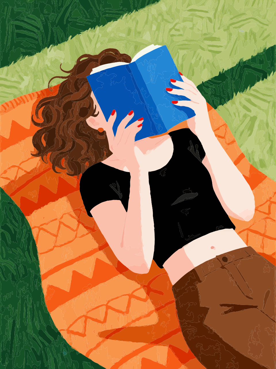 Young woman reading a book on a blanket in grass.