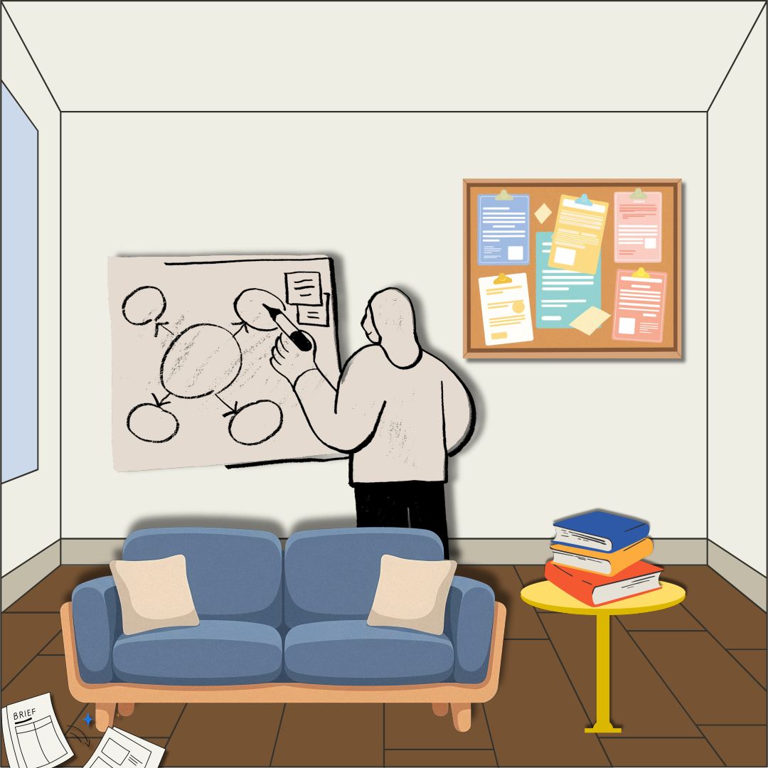 ソファと本の隣でホワイトボードに絵を描く人物